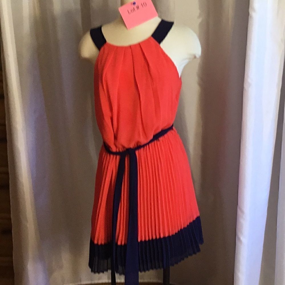 Sleeveless dress with pleated skirt in pinkish orange & navy, matching belt